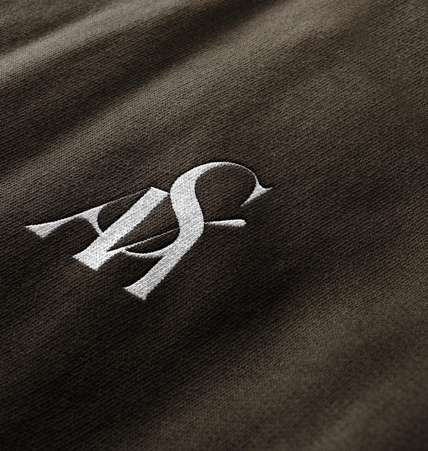SÁVA monogram embroidered on dark fabric